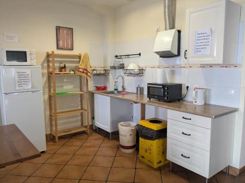 a kitchen with a counter with a microwave and a refrigerator at Albergue Nido de Cigüeña in Nájera