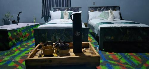 a bedroom with two beds and a wooden box on the floor at Amboseli Amanya Lodge in Rift Valley