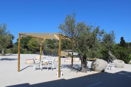 a pavilion with white chairs and tables in a park at NOHA Lifestyle Hotel - Adults Only in Pula
