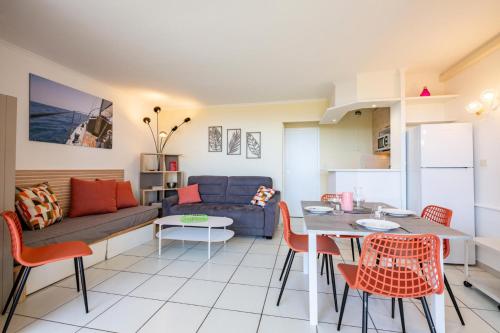 un salon avec un canapé, une table et des chaises dans l'établissement Résidence le Village de Cap Esterel - maeva Home - Appartement 2 Pièces 5 Personnes - Prestige - super Home MAE-2135, à Saint-Raphaël