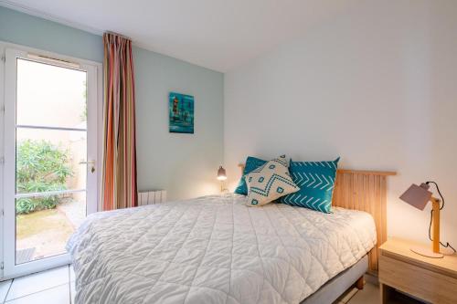 une chambre avec un lit et une grande fenêtre dans l'établissement Résidence le Village de Cap Esterel - maeva Home - Appartement 2 Pièces 5 Personnes - Prestige - super Home MAE-2135, à Saint-Raphaël