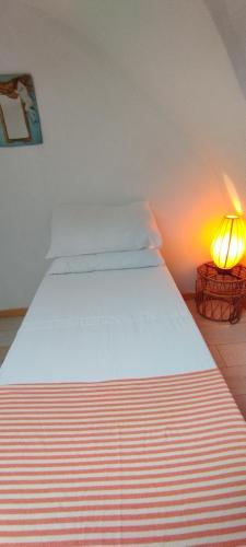 a bed in a room with a lamp next to it at Dimora Maltese in Morciano di Leuca