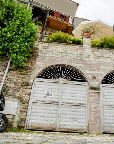 a building with two garage doors with a sign on it at The Home of Diplomacy in Gjirokastër