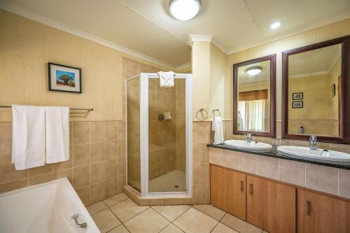 ヘイジービューにあるKruger Park Lodge Unit No 303の洗面台2つとシャワー付きのバスルーム