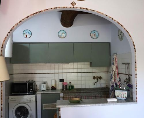 a kitchen with green cabinets and a washer at Antiche Fonti in Bibbona