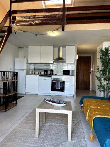 un salon avec une table et une cuisine dans l'établissement La Madrague Waterfront Cottage, à Hyères