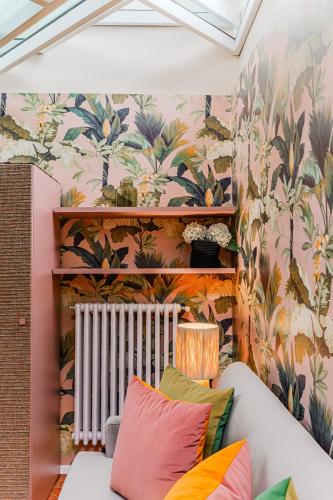 a living room with floral wallpaper and a couch at Appartamento La Torre in Pistoia