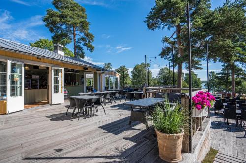 an outdoor patio with tables and chairs and trees at Gröna Uddens Camping in Mariehamn