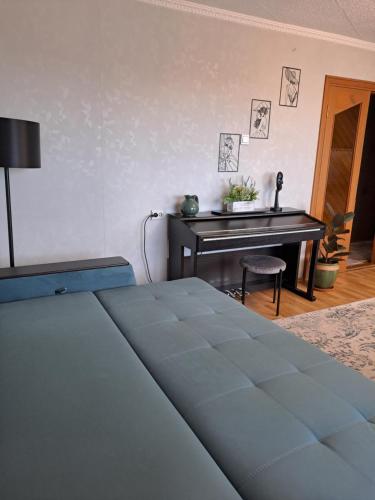 a bedroom with a bed and a table and a piano at DREAMSVILLE in Ventspils