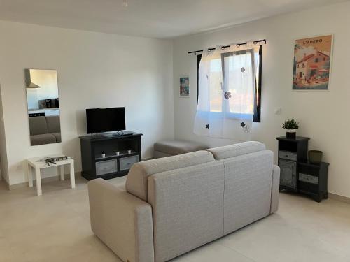 un salon avec un canapé et une télévision dans l'établissement Sérénité au Coeur de la Provence, à Cuges-les-Pins