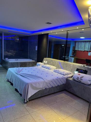 a large bed in a room with blue lights at Motel Blue Star II in Campo Mourão