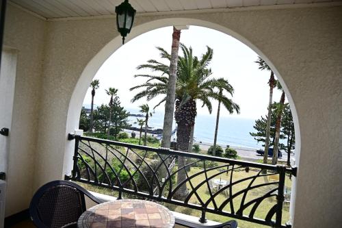 an arched balcony with a view of the ocean at Jennyville Pension in Seogwipo
