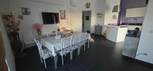 a dining room with a table and chairs and a kitchen at Appartamento in villa Gra&Mary in San Giovanni in Marignano