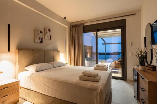 a bedroom with a bed with a view of the ocean at Villa Scorpios View in Nydri