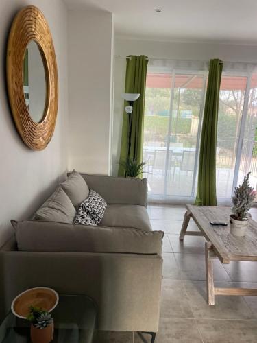 un salon avec un canapé, une table et un miroir dans l'établissement Le Grand Gite, à Collorgues