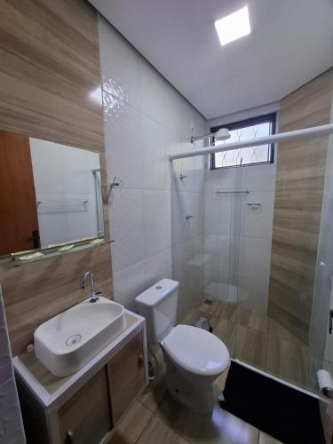 a bathroom with a toilet and a sink and a shower at Pousada Manacá in São José do Rio Pardo