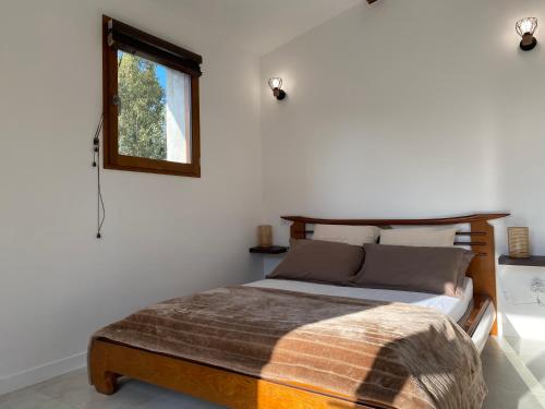 une chambre avec un lit et une fenêtre dans l'établissement Bergerie A Mandria di Rondinara, à Bonifacio