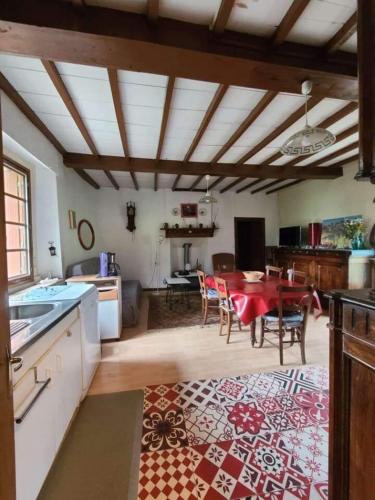 une cuisine et une salle à manger avec une table et des chaises dans l'établissement Moulin à eau au cœur des Baronnies, à Esparros