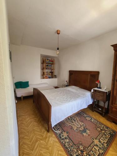 une chambre avec un grand lit et une table dans l'établissement Moulin à eau au cœur des Baronnies, à Esparros