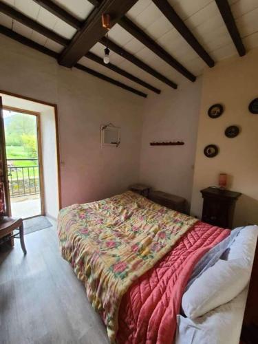 une chambre avec un lit dans une pièce avec une fenêtre dans l'établissement Moulin à eau au cœur des Baronnies, à Esparros