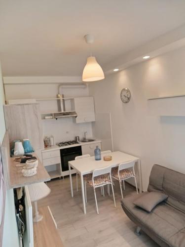 a kitchen and living room with a table and a couch at Sole e mare in Porto SantʼElpidio