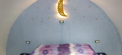 a room with a bed and a light on the wall at Dimora Maltese in Morciano di Leuca