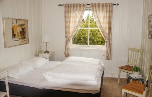 a bedroom with a white bed and a window at Sandli Overnatting in Alvdal