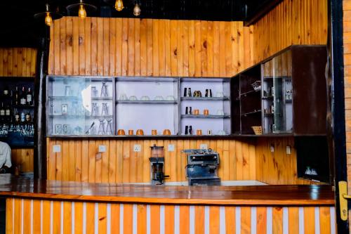 a bar with wooden walls and a counter with alcohol at Quality Inn Hotel Kigali in Kigali