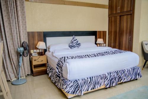 a bedroom with a large white bed and a nightstand at Quality Inn Hotel Kigali in Kigali