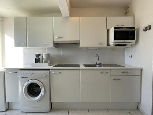 une cuisine avec un lave-linge et un micro-ondes dans l'établissement Villa Port Nature VPN134 - 2 personnes, au Cap d'Agde