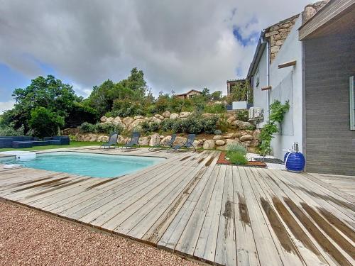 une piscine avec une terrasse en bois à côté d'une maison dans l'établissement Bergerie A Mandria di Rondinara, à Bonifacio