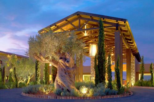 a building with a tree in front of it at The Westin Resort, Costa Navarino in Romanós