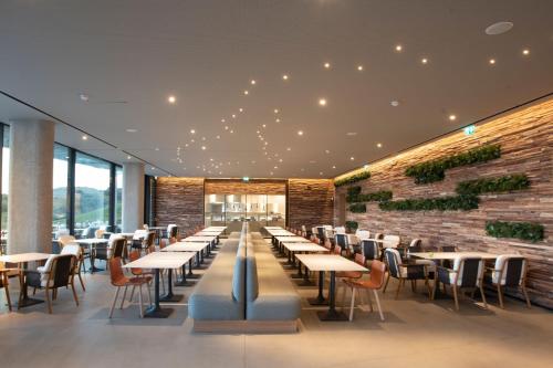 a restaurant with tables and chairs and a brick wall at The Westin Resort, Costa Navarino in Romanós
