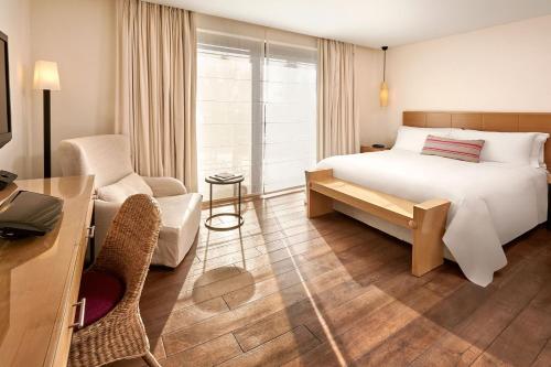a hotel room with a bed and a desk and chair at The Westin Resort, Costa Navarino in Romanós
