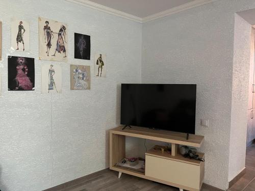 Una sala de estar con un televisor de pantalla plana en una pared. en Cozy Tbilisi Home, en Itʼkhvisi