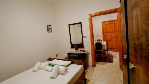 a bedroom with a bed with towels on it at The Home of Diplomacy in Gjirokastër