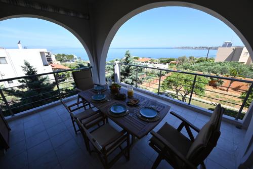 a balcony with a table and chairs and a view of the ocean at Unick Seaview Luxury Living in Kalathas