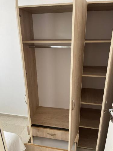 a cupboard with wooden shelves in a room at New house in Dobra Voda