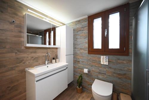 a bathroom with a toilet and a sink and a mirror at Unick Seaview Luxury Living in Kalathas