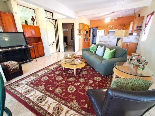 a living room with a couch and a tv at Villa Hermosa Ocean View 2 Bed in San Carlos