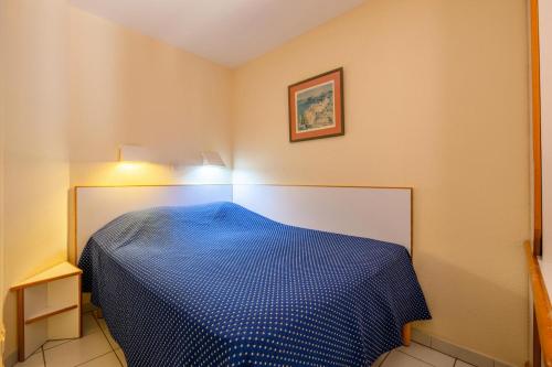 - une chambre avec un lit bleu dans l'établissement Résidence le Hameau de Cap Esterel - maeva Home - Appartement 2 pièces 5 personnes - Confort MAE-5664, à Saint-Raphaël