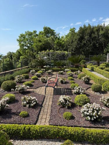 a park with a bench in the middle of a garden at Bed and Breakfast Villa Iris in Mošćenička Draga