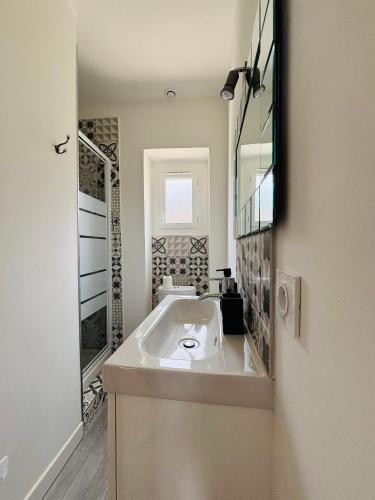 une salle de bain blanche avec un lavabo et un miroir dans l'établissement Straboni corte, à Corte