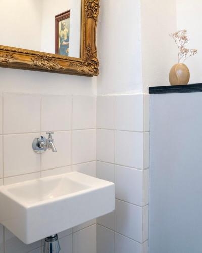 a white bathroom with a sink and a mirror at Authentic Amsterdam Apartment RAI in Amsterdam