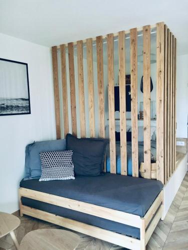 a bed in a room with a wooden wall at Magnifique petit cocon bord de mer in Le Pradet