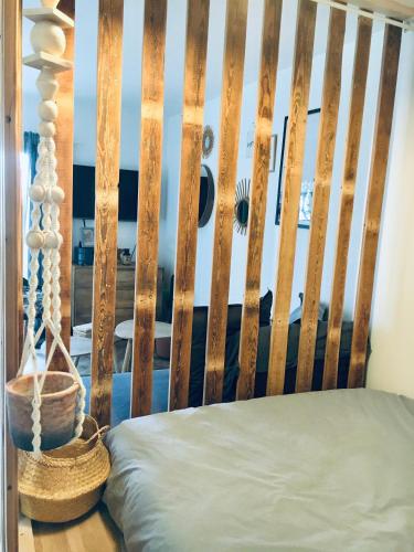 a bed with a wooden headboard with a basket at Magnifique petit cocon bord de mer in Le Pradet
