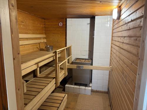 una stanza con scaffali di legno in una cucina con una stufa di Malmi Home a Vaasa