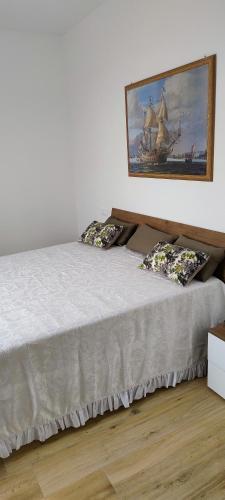 a bed in a room with a painting on the wall at Terrazza mare e monti in Alba Adriatica