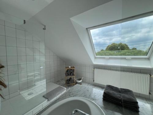 un bagno con doccia, lavandino e finestra di Maisonette Ferienappartement mit Garten a Donaueschingen