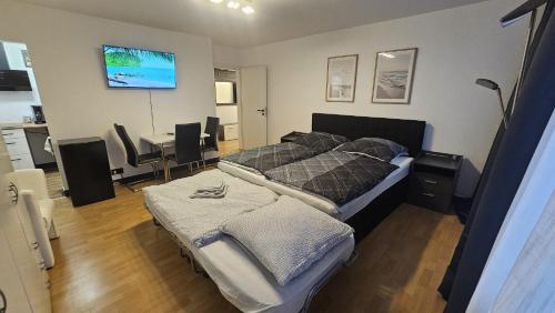 a bedroom with a bed and a desk with chairs at Hotel Essen 32 1-Zimmer Apartment in Essen